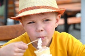 Close up image of BOY hand holding fresh waffle cone with vanilla