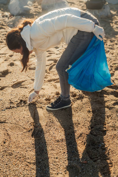 istock Young girl collecting garbage on beach 1932793163