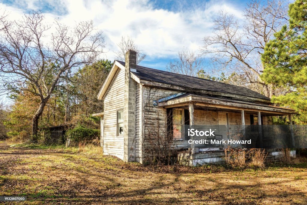 Abandoned American Farmhouse A rustic landscape of an old, abandoned farmhouse with a front porch in North Carolina in the United States. Abandoned Stock Photo