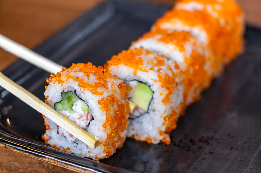 Sushi, shot from the top. Rolls, maki, nigiri on a black slate background, Japanese food. Salmon, eel, shrimp, tuna etc with rice, with a place for text