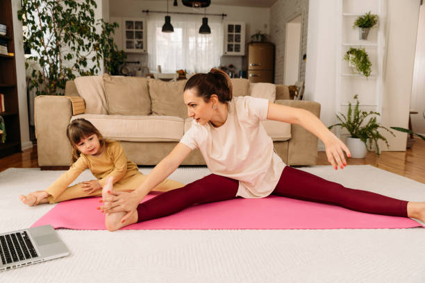 istock Mother and child having fun while stretching and exercise at home 1932881122