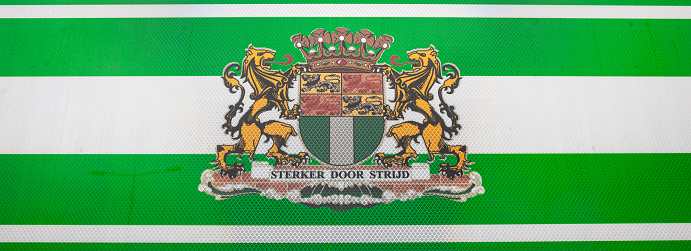 Rotterdam, Netherlands - January 12, 2024: Road sign with a green-white banner and coat of arms of the city of Rotterdam.