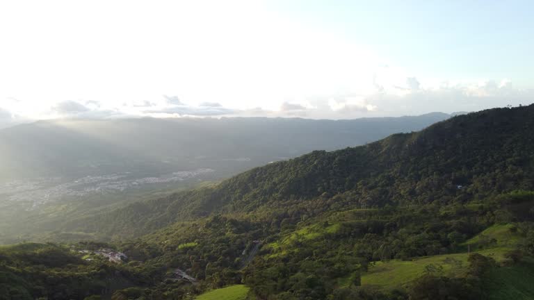 aerial shot, drones flying over a beautiful green mountains and amazing sunny rays over guaduas city in Cundinamarca Colombia 4K