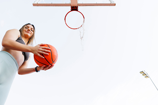 Portrait of active young 7 year's old Caucasian girl playing with a basketball ball