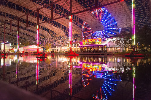 St. Louis, Missouri - USA: The Train Shed in the old St. Louis Union Station, at night with colorful lights, ferris wheel, and reflections in water.