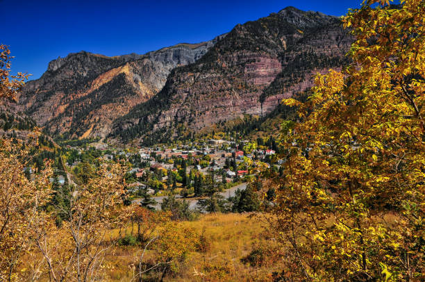 Panoramic view of Ouray village surrounded by fall colors on the rugged and rocky San Juan mountains, Colorado, USA.