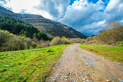Wet countryside road, white clouds and blue sky on Stara Planina, Serbia
