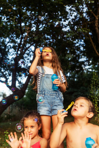 istock Children having fun blowing bubbles in the yard 1932997536