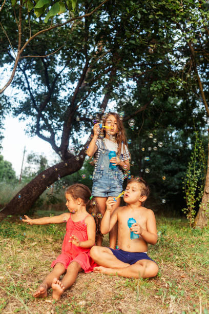 Group of children having fun blowing bubbles in the yard