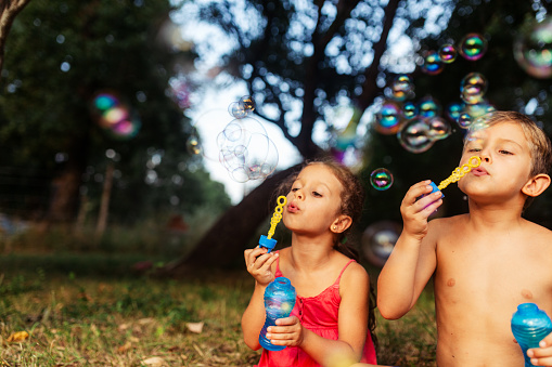 Group of children having fun blowing bubbles in the yard