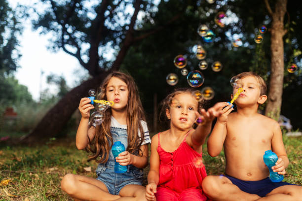 istock Children having fun blowing bubbles in the yard 1932999619