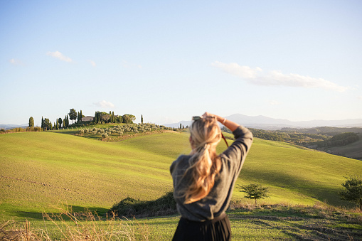 Young woman photographer explores Tuscan countryside