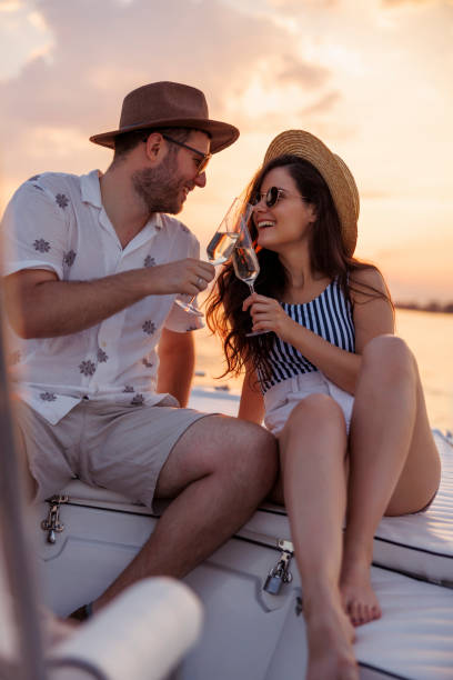 istock Couple making a toast and drinking champagne while sailing to the sunset 1933013587