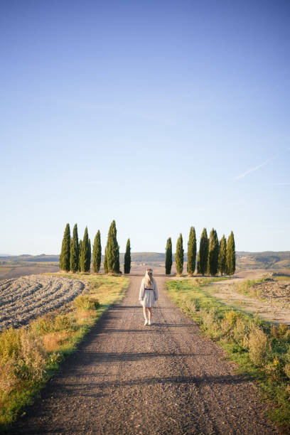 istock Young woman walks down country road 1933019355