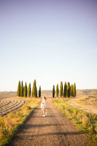 istock Young woman walks down country road 1933023041