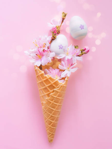 istock Easter eggs, cherry blossom flowers, waffle cone on a pink background with bokeh and copy space. Vertical creative photo. Church Christian holidays, Christianity, Easter background 1933032613