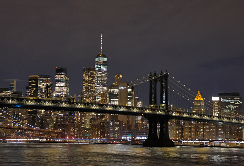 View of Manhattan Bridge and iconic New York skyline taken from the East River.