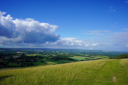 Views over countryside farm fields with clouds in blue sky in the summer