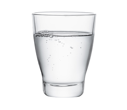 A full glass of drinking water on a kitchen counter near the sink.