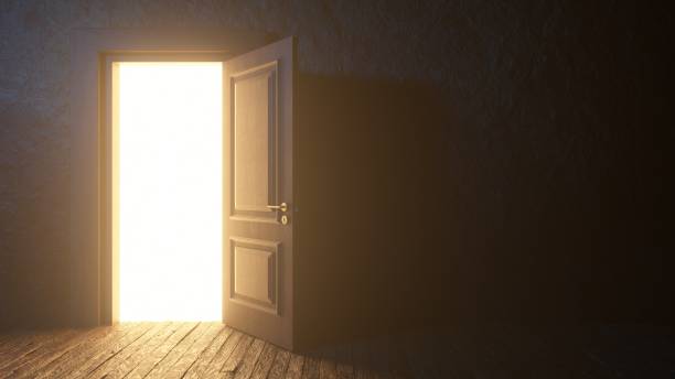 istock Light shines from door opening in dark room 1933097270