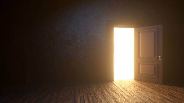 istock Light shines from door opening in dark room 1933097784