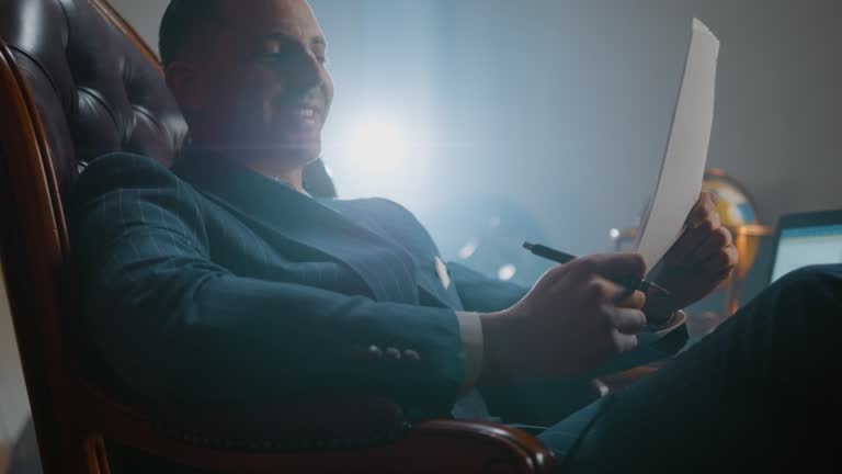 Happy business man holding document, receiving letter, reading legal paper, reviewing project. He feels satisfied and successful