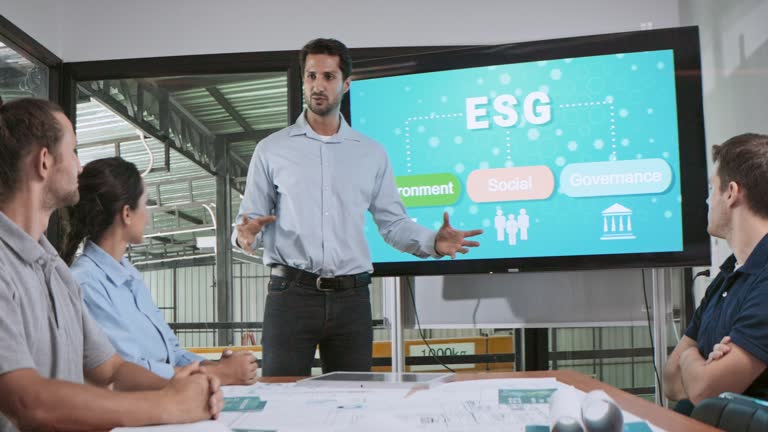 Engineer team brainstorm meeting in factory office. Presentation on ESG project planning, solar panel, wind turbine power generation, environmental sustainable energy efficient. Industrial business