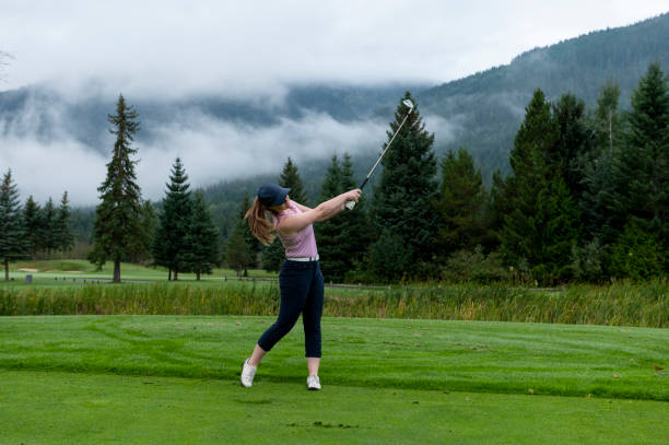 woman golfing on mountain golf course - golf women female concentration - fotografias e filmes do acervo