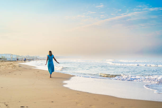 istock Beautiful woman walking on beach 1933146353