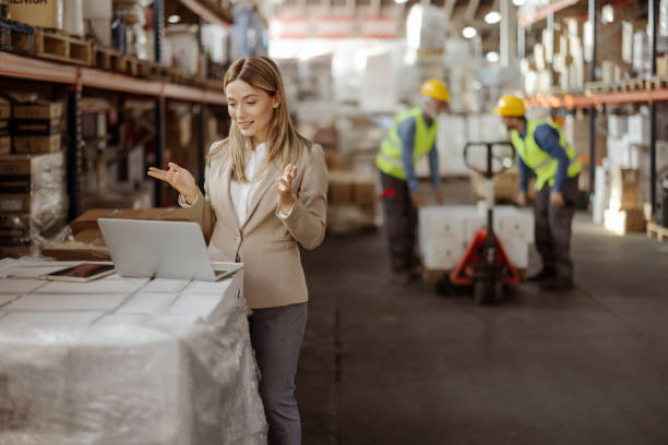 istock Businesswoman Using Laptop at Warehouse 1933197791