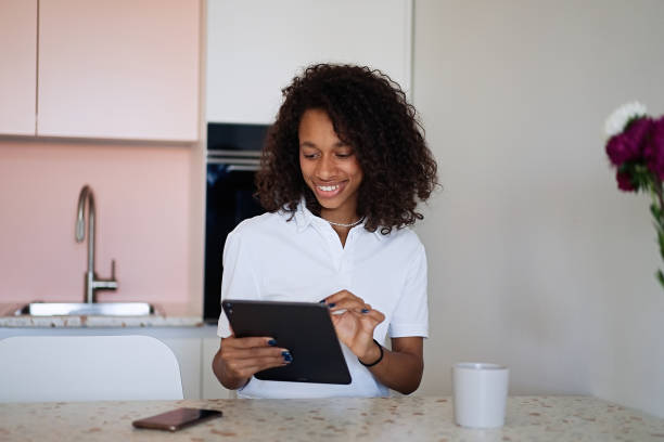 istock Beautiful young woman drinking coffee and using a tablet 1933200967