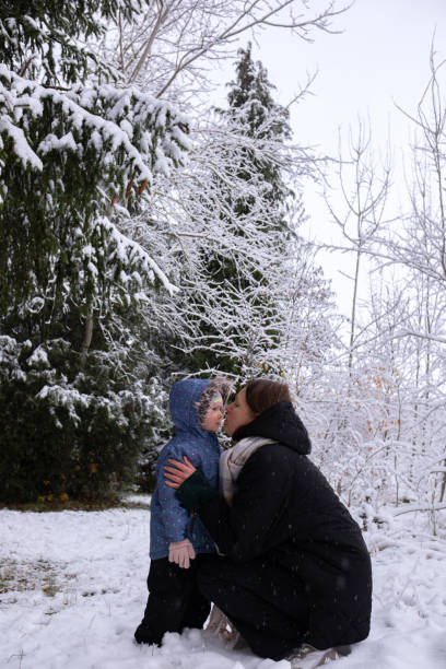 istock Mom with daughter in winter snowy forest. 1933203106