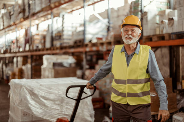istock Senior Male Worker With Manual Forklift in Warehouse 1933206762