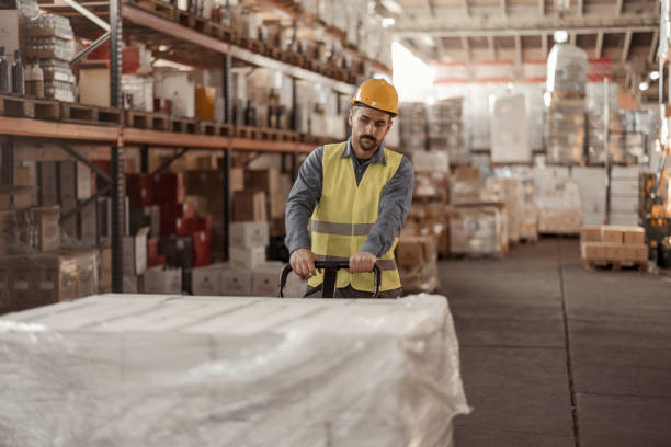 istock Manual Worker with Pallet Jack in Warehouse 1933214054
