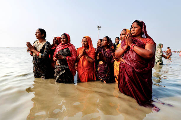 Ganga Sagar, West Bengal, India, 01_14_2024: Women devotees taking holy bath at Gangasagar. After the bath they perform pujas and other rituals in remembrance of their departed family members/close relatives and they also seek blessings for their departed souls.Gangasagar pilgrimage and fair, held annually, is the second largest congregation of mankind after the holy Kumbha Mela. Almost a million of Hindu devotees from all over India gather at Gangasagar for a holy dip and perform rituals and prayer (puja) with a belief that it will cleanse and purify their souls.Gangasagar Festival is in Hinduism, held every year at Gangasagar, West Bengal, India. The confluence of the Ganges and the Bay of Bengal is called the Gangasagar, the fair is held every year on Makar Sankranti at Kapilmuni's ashram located on the Gangasagar. The mela is celebrated on 14 or 15 January every year.