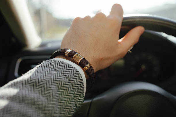 istock Classical male leather bracelet on a hand in the car 1933243254