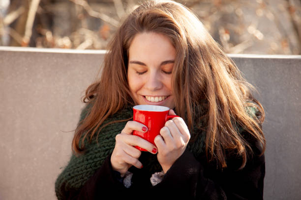 Young woman drinking coffee and enjoying autumn