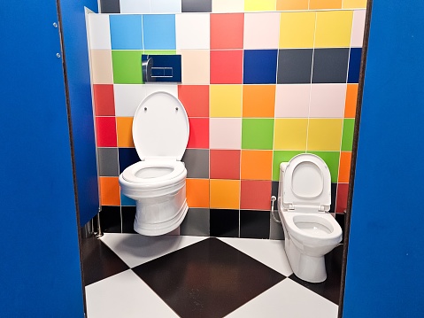 Shared family bright restroom with two toilet bowl in mall. Unisex WC for woman, man, mom dad, boy girl, kid. Use together. Recreation room, toilet for adult,little child. Big parents, children cabin.