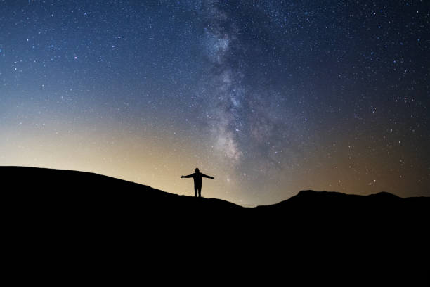 istock Silhouette  standing on the hill, on the milky way galaxy background. 1933272169