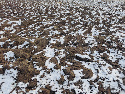 Small business farm in winter. Frozen plowed fields covered with snow.