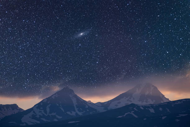 istock Beautiful night landscape. Snow covered mountains under beautiful bright Milky Way Galaxy. 1933277911