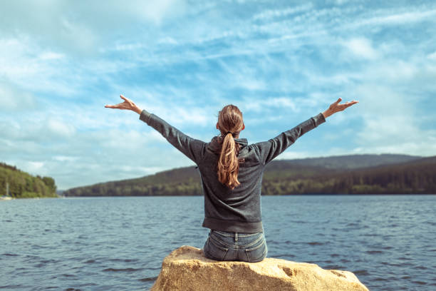 istock Happy, joyful woman relaxing by the waters edge. 1933311256