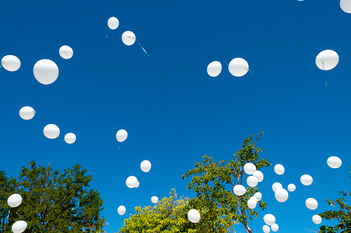 White balloons are released into the Jamaican blue sky