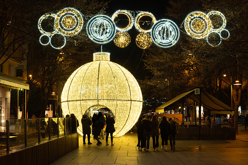people admire giant ball of light and Christmas decorations in Pamplona Navarra Spain 12.10.2024 .