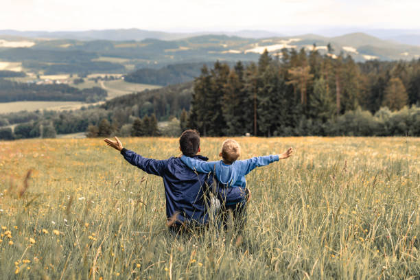 istock Father and son feeling free together in the meadow. 1933328662