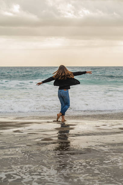 istock Happy woman dancing liberally on the beach. 1933346300