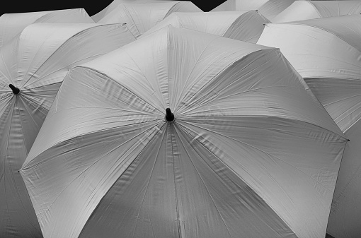 a group of umbrellas with silver cloth on a black background