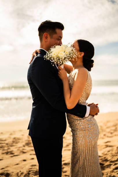 istock Bride and groom kissing on the beach 1933359988