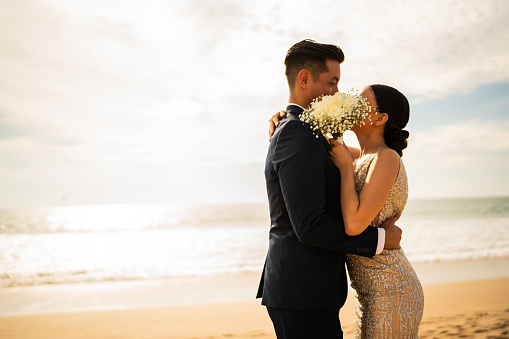 Bride and groom kissing on the beach