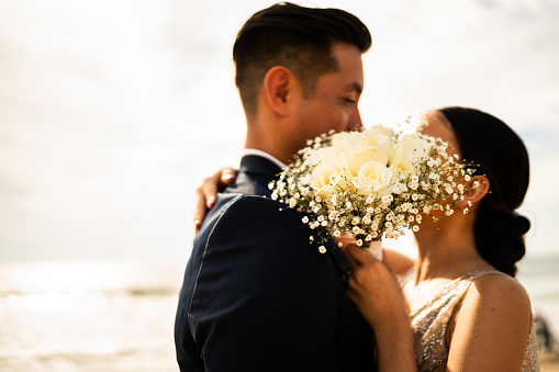 Close-up of a bride holding a bouquet on the beach